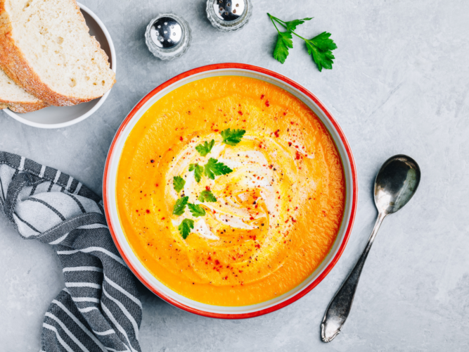 bowl of butternut squash soup with dollop of yogurt and parsley