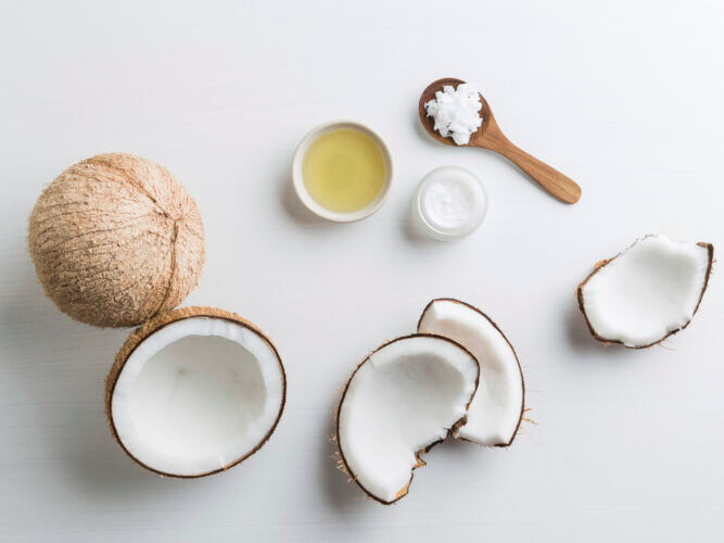 cracked open coconut and coconut oil in bowls