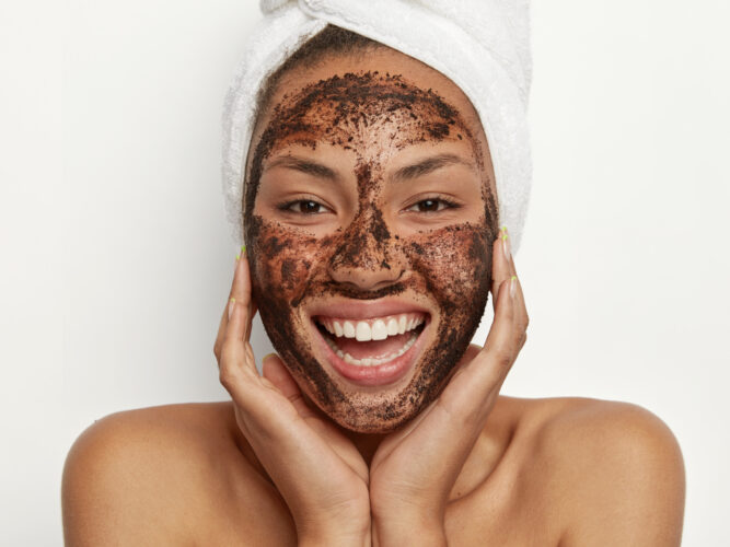woman rubbing on a clean coffee face mask