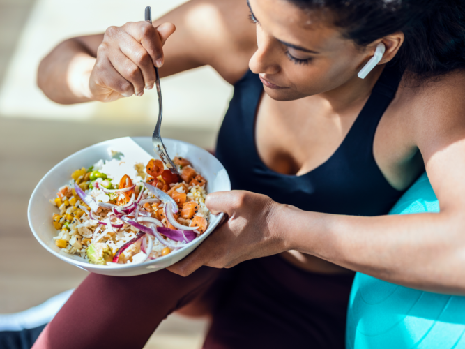 fit woman eating a healthy salad