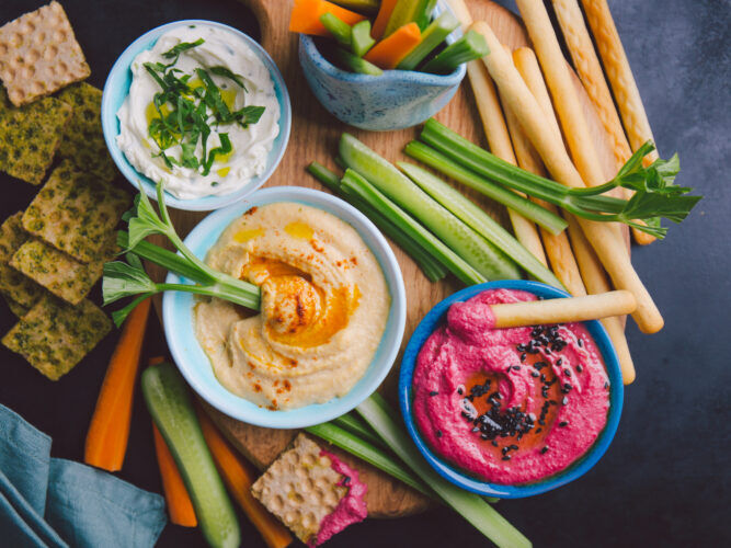 veggies and dips on a board with crackers