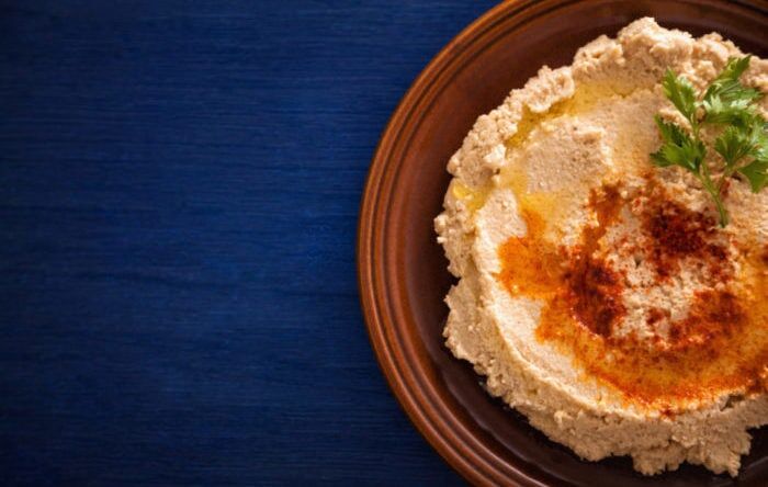 Hummus on a plate with parsley and olive oil on it