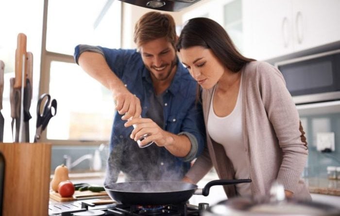 A young couple making dinner together at home