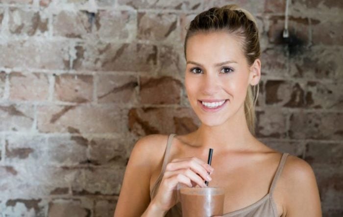 Young woman having a chocolate milkshake and looking very happy at a restaurant