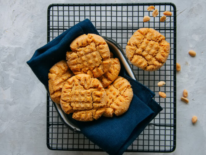 peanut butter cookies in a bowl with a napkin on a cooling rack