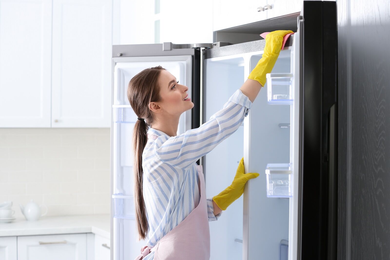 Woman,In,Rubber,Gloves,Cleaning,Refrigerator,At,Home