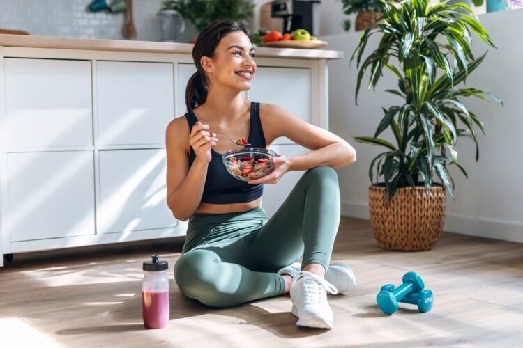 Happy athletic woman eating