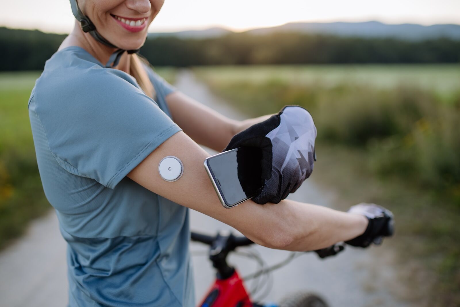 Diabetic,Cyclist,Connecting,Continuous,Glucose,Monitor,With,Her,Smartphone,To